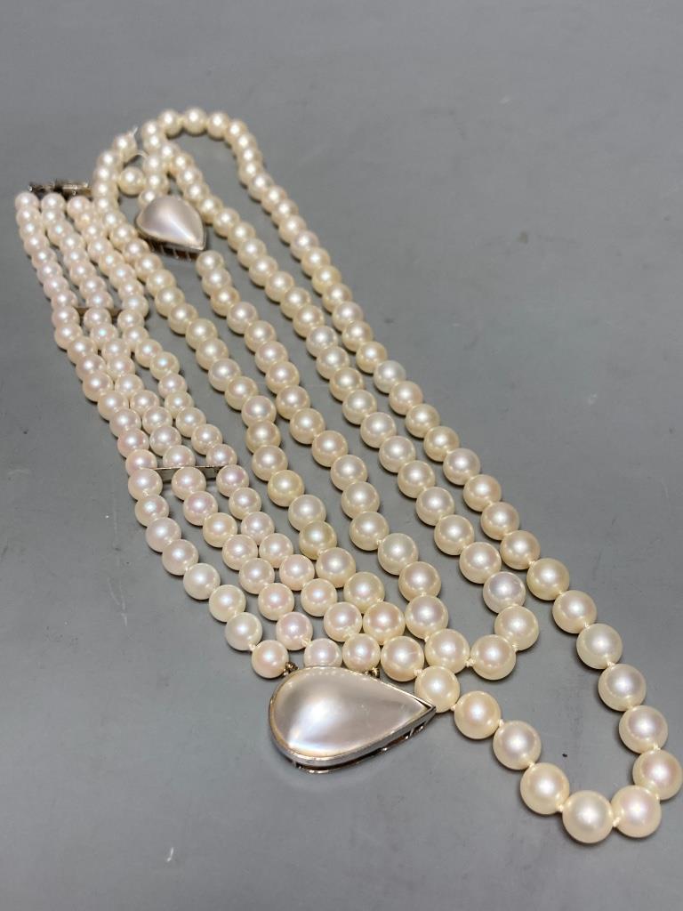 A single strand cultured pearl necklace, with a mother of pearl set 14k white metal clasp, 90cm, gross weight 66.5 grams and matching triple strand bracelet, 18.5cm, gross weight 34.7 grams.